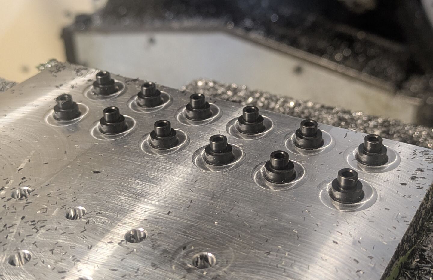 Multiple workpieces secured on a machine bed during manufacture